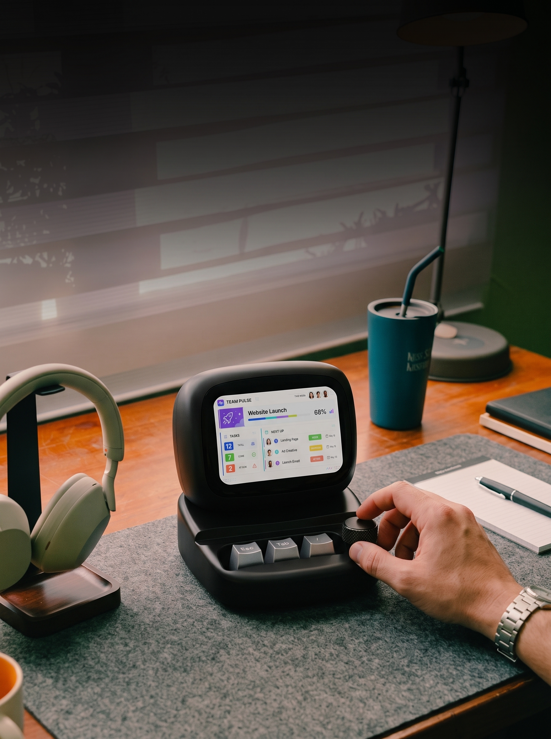 App concept: a team project dashboard running on Y1, with a hand on its control knob